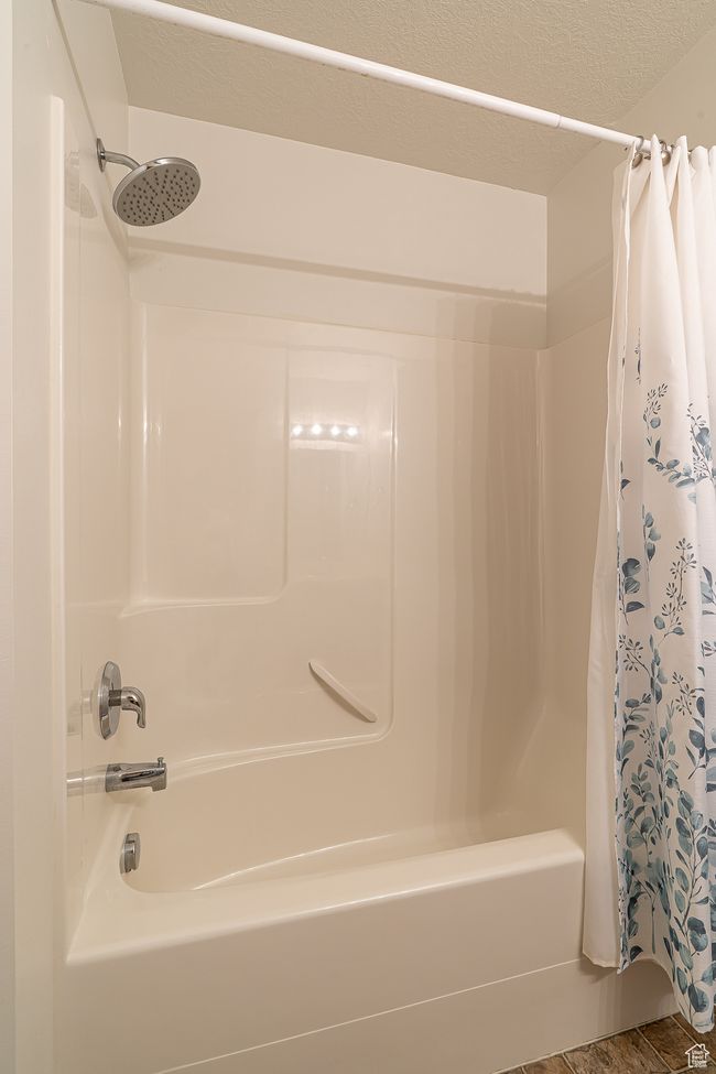 Full bathroom featuring a textured ceiling and shower / bath combo with shower curtain | Image 24