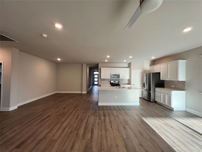 Kitchen with appliances with stainless steel finishes, open floor plan, decorative backsplash, dark wood-style floors, and recessed lighting | Image 8