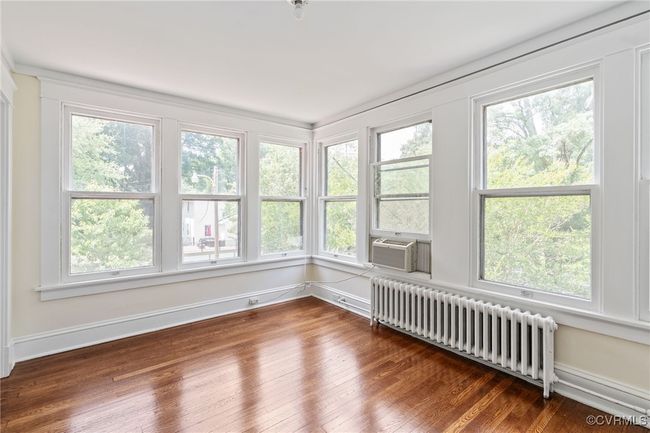Bedroom featuring radiator heating unit, plenty of natural light, and cooling unit | Image 35