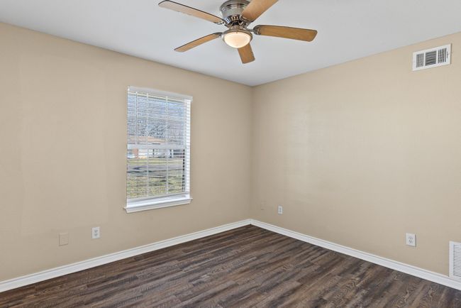 Spare room featuring dark wood-type flooring, visible vents, baseboards, and a ceiling fan | Image 17