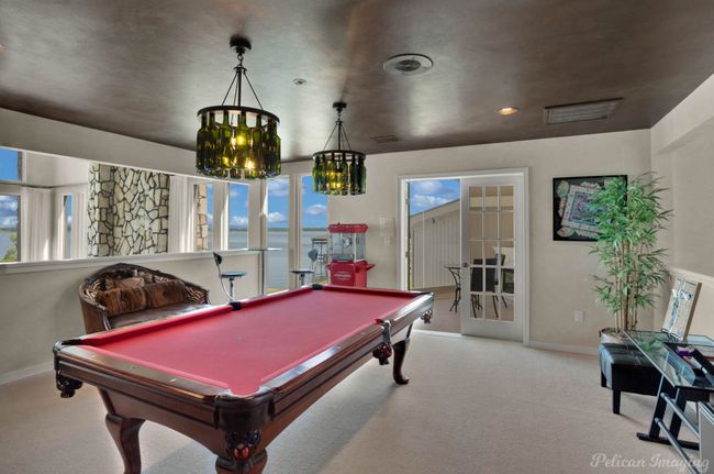 Game room featuring a notable chandelier, a water view, baseboards, and carpet floors | Image 18