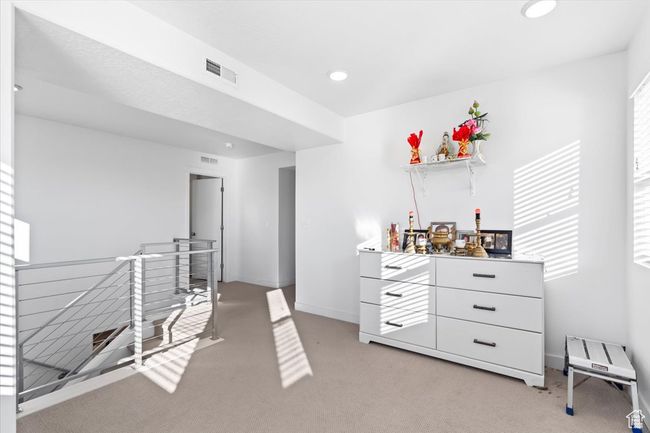 Interior space featuring a dry bar, baseboards, visible vents, recessed lighting, and light colored carpet | Image 18