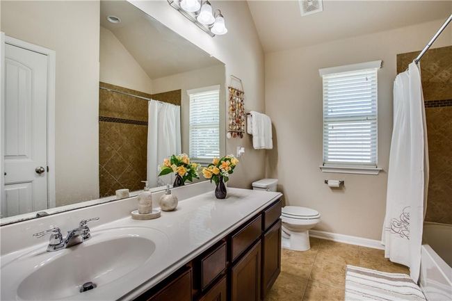 Bathroom with healthy amount of natural light, vaulted ceiling, vanity, tile patterned flooring, and shower / tub combo with curtain | Image 19