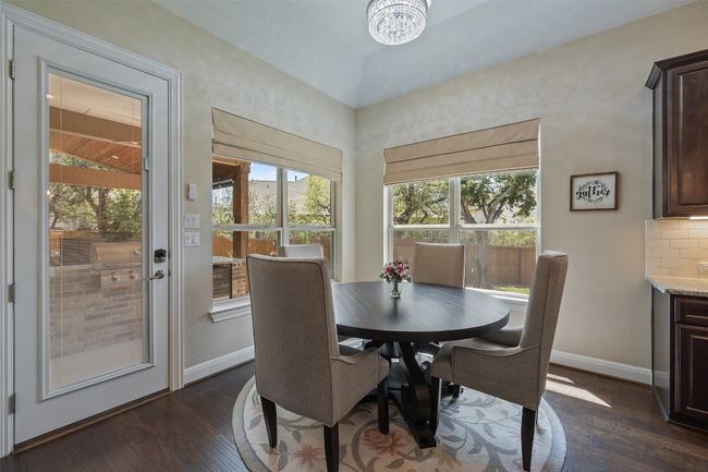 Breakfast area featuring beautiful dark wood finished floors and a healthy amount of sunlight & views of the outdoor oasis | Image 12