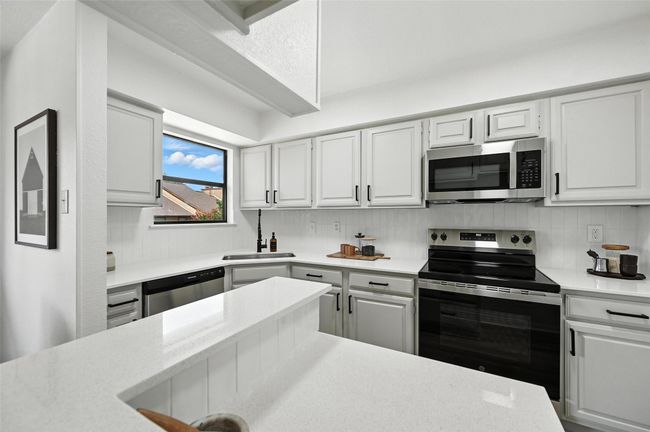 Kitchen featuring appliances with stainless steel finishes, light countertops, and decorative backsplash | Image 16