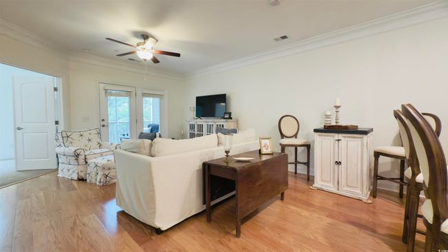 Living room featuring light wood finished floors, ceiling fan, and ornamental molding | Image 17