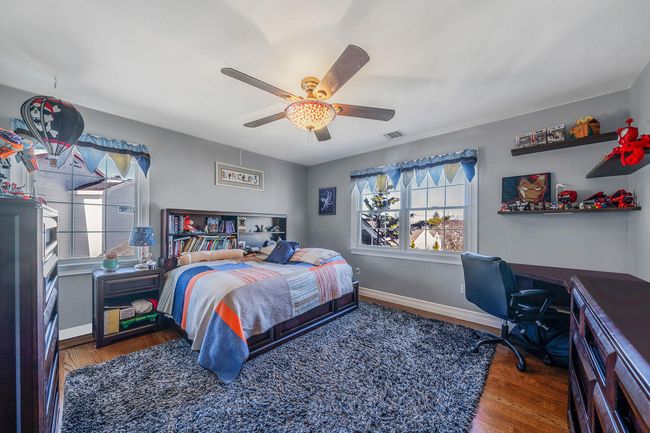 Bedroom featuring baseboards, wood finished floors, and multiple windows | Image 21