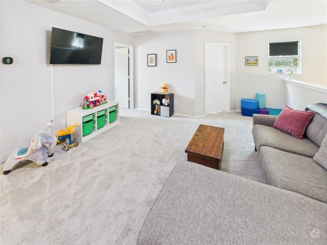Living room featuring carpet floors, crown molding, a raised ceiling, and ceiling fan | Image 17