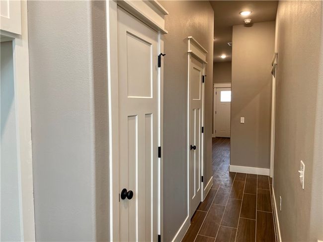 Hallway to 1/2 bath, primary suite, and garage | Image 20
