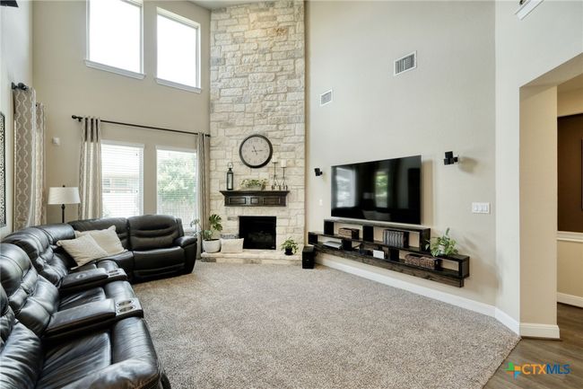 Features a corner fireplace and lots of windows, neutral pallett | Image 6