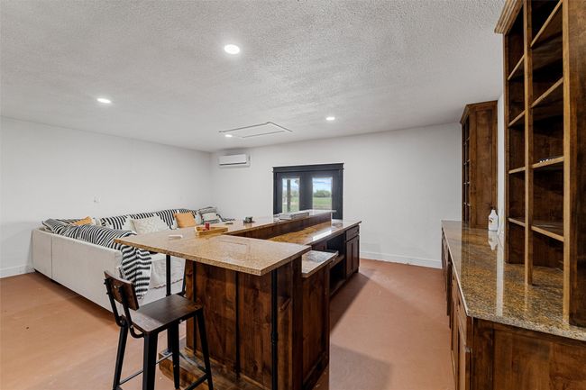 man cave recessed lighting, a wall mounted AC, and a kitchen bar | Image 26