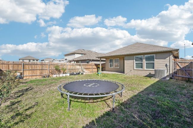 View of yard with a trampoline, central AC unit, and a fenced backyard | Image 24