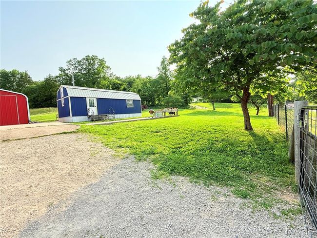 View of yard featuring an outdoor structure, a pole building, and view of wooded area | Image 5