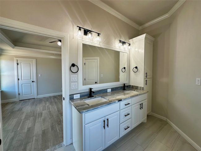Bathroom featuring ornamental molding, double vanity, a ceiling fan, and baseboards | Image 14