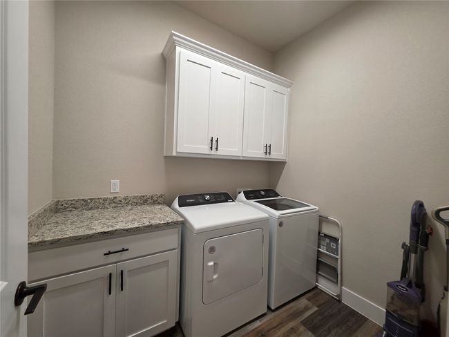 Laundry room with cabinet space, washing machine and dryer, and dark wood-type flooring | Image 18
