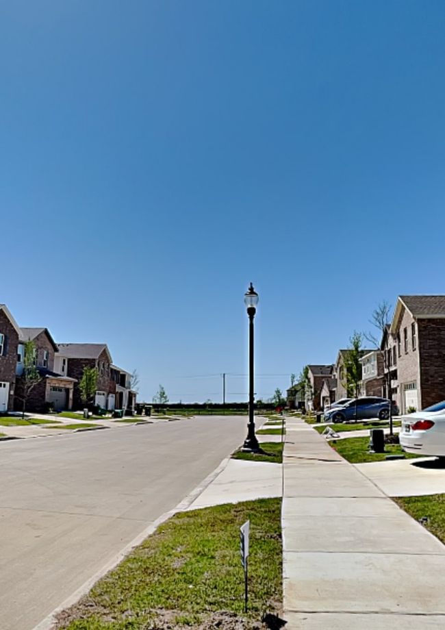 View of concrete street featuring a residential view, street lights, and sidewalks | Image 39