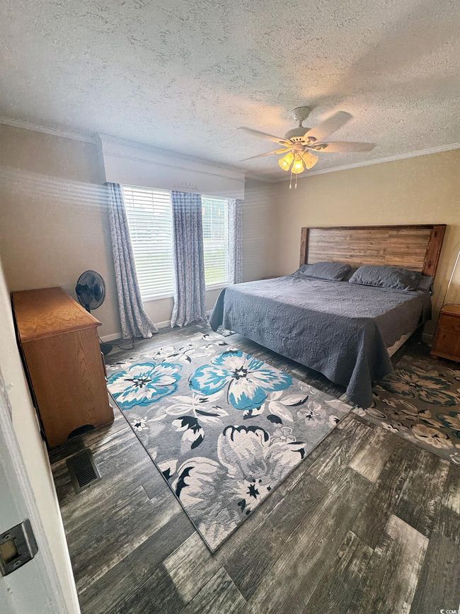 Bedroom with wood finished floors, a textured ceiling, and ceiling fan | Image 19