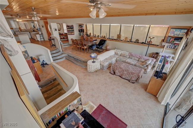 Tiled living room featuring a ceiling fan and wood ceiling | Image 39