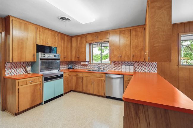 Kitchen featuring stainless steel dishwasher, decorative backsplash, plenty of natural light, and oven | Image 15
