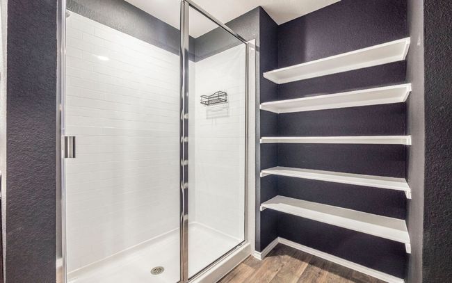 Bathroom with wood finished floors, a shower stall, and a textured wall | Image 13