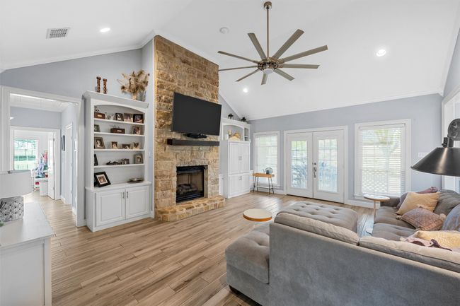 Living room with light wood-style flooring, ornamental molding, a ceiling fan, visible vents, and french doors | Image 33
