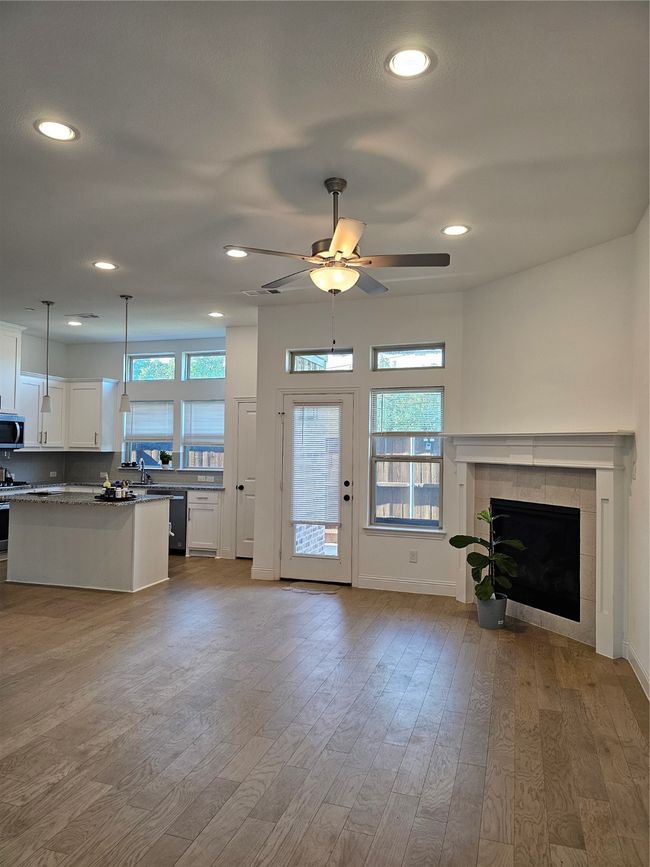 Unfurnished living room with plenty of natural light, hardwood / wood-style flooring, ceiling fan, and recessed lighting | Image 7