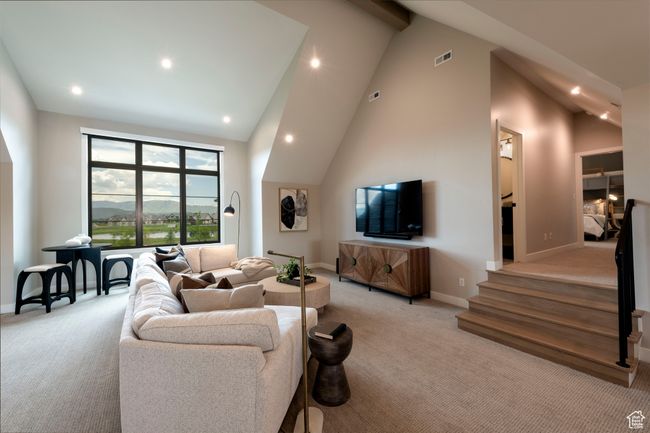 Living room featuring light colored carpet, recessed lighting, stairway, high vaulted ceiling, and beamed ceiling | Image 42