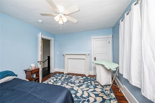 Bedroom with wood finished floors, ceiling fan, and baseboards | Image 23