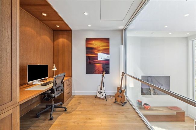 Just off the second-floor flex space, a custom work station is thoughtfully designed with a large interior window. By incorporating glass instead of a solid wall, the architect maximized the flow of natural light—creating an inspiring and bright environment for work, study, or creativity. | Image 28