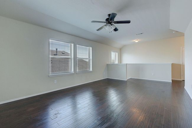 Spare room featuring a ceiling fan, wood finished floors, and baseboards | Image 16