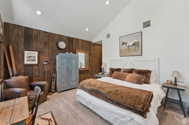 Bedroom with wood walls, carpet, high vaulted ceiling, and recessed lighting | Image 22