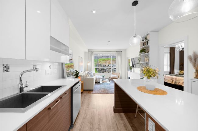 Kitchen featuring dishwasher, modern cabinets, a sink, white cabinetry, and light countertops | Image 13
