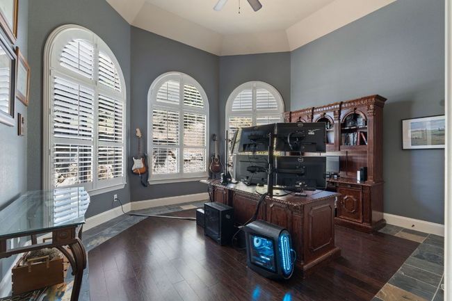 Office space a ceiling fan, a high ceiling, and hardwood floors | Image 22