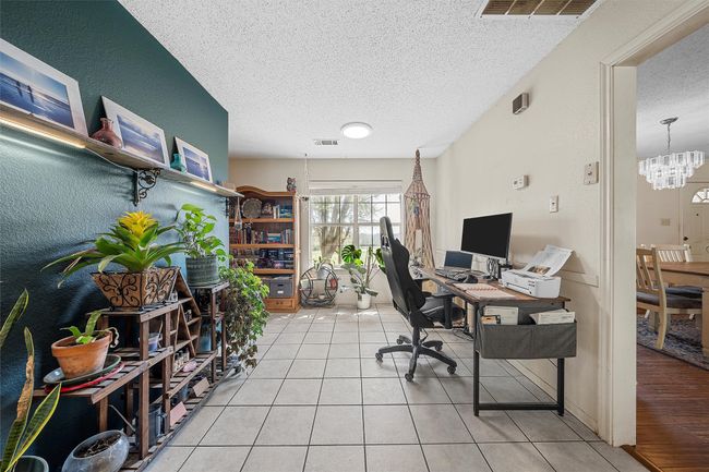Office area featuring an inviting chandelier, visible vents, a textured ceiling, and light tile patterned flooring | Image 14
