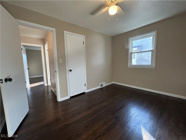 Second bedroom with a ceiling fan and dark wood-style flooring. | Image 22