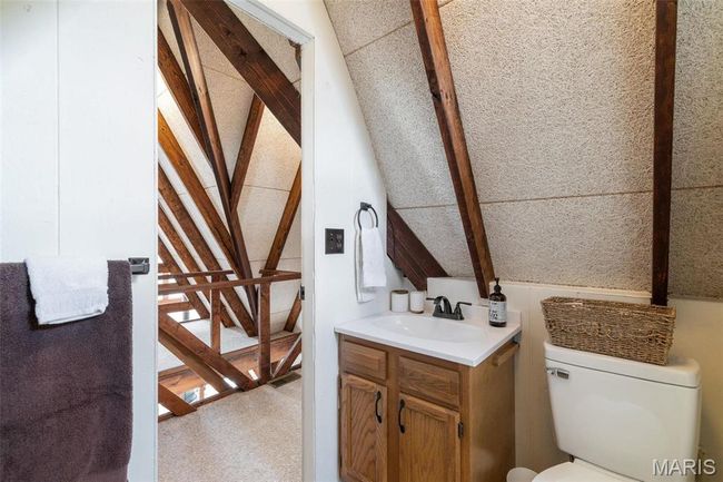 Half bathroom with lofted ceiling, toilet, and vanity | Image 39