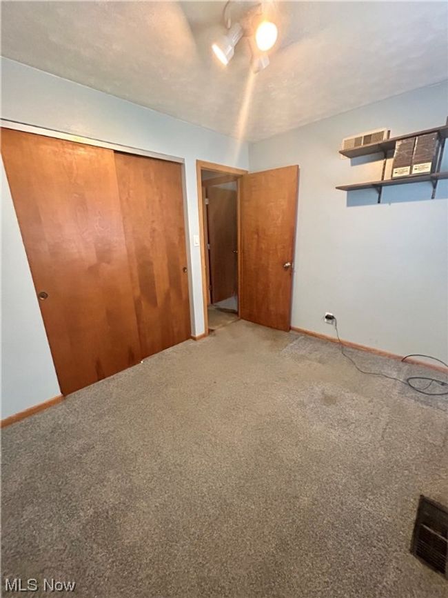 Unfurnished bedroom with light carpet and a closet | Image 17