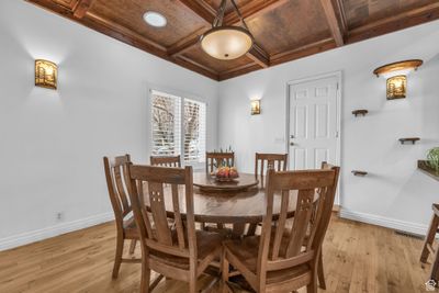 Dining space with coffered ceiling, ornamental molding, beam ceiling, and light hardwood / wood-style flooring | Image 3