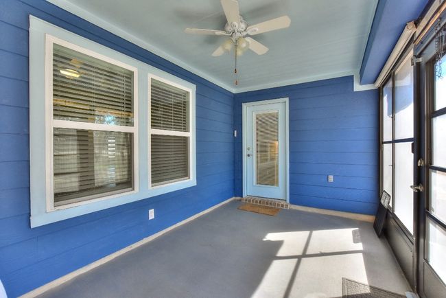 Back porch has ceiling fan and is enclosed with screens. | Image 27