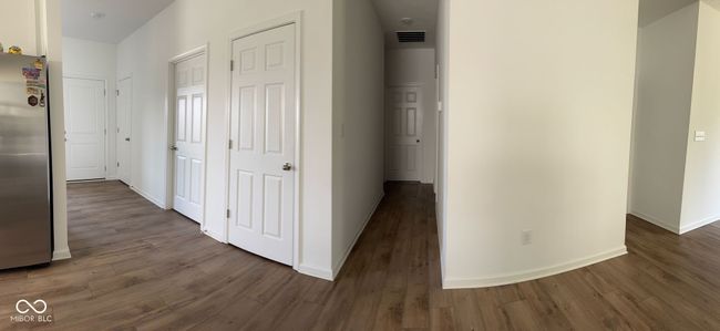 hall featuring baseboards, visible vents, and dark wood-style floors | Image 8