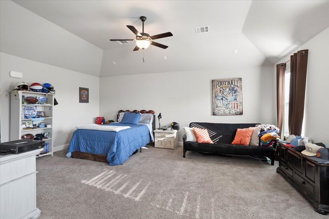Bedroom featuring lofted ceiling, visible vents, baseboards, a ceiling fan, and carpet | Image 26