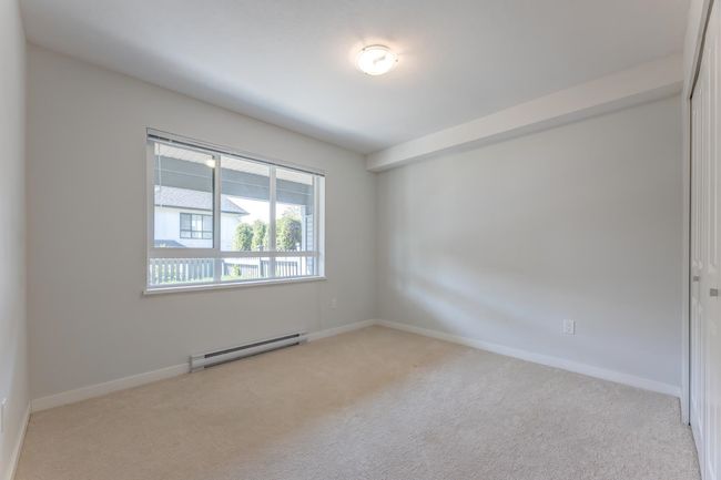 Carpeted spare room with a baseboard heating unit and baseboards | Image 30