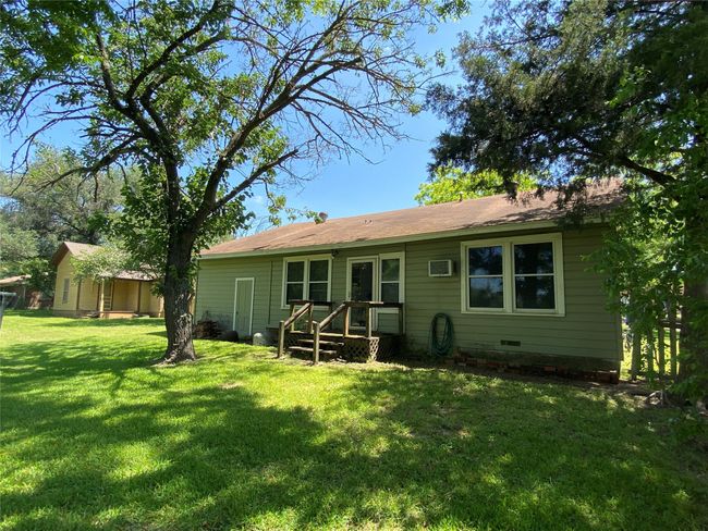 Rear view of property with a lawn, an AC wall unit, and crawl space | Image 9