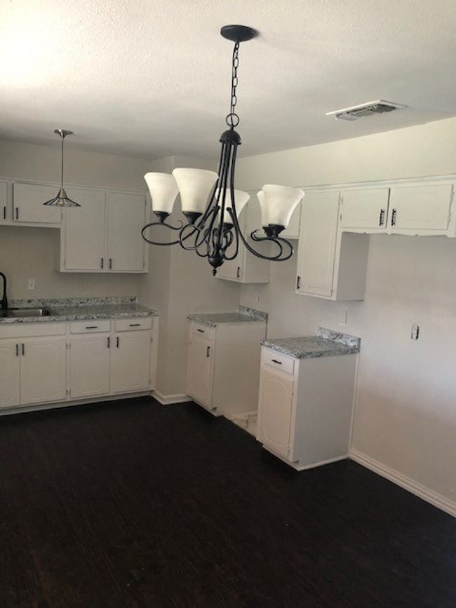 Kitchen featuring white cabinetry and crown molding | Image 4