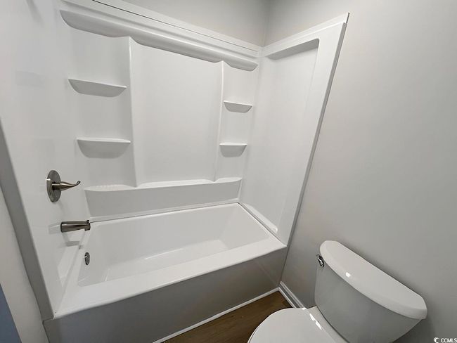 Full bath featuring toilet, shower / washtub combination, and wood finished floors | Image 21
