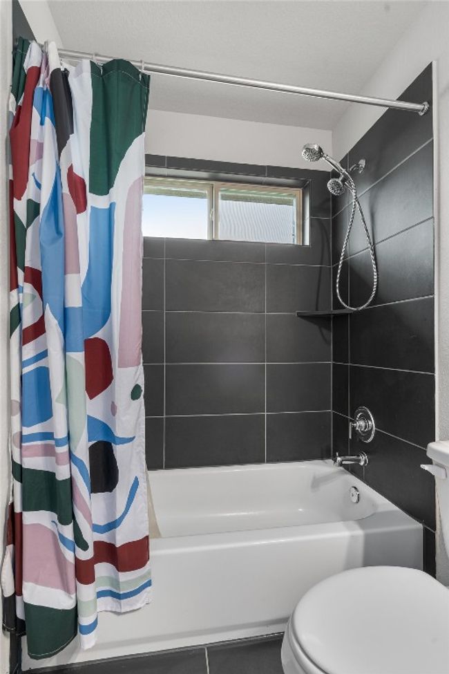 Full bathroom with shower / tub combo, toilet, and tile patterned flooring | Image 30