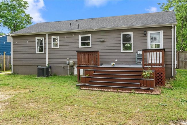 Back of property with central air condition unit, a yard, roof with shingles, a deck, and fence | Image 36