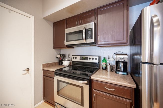 Kitchen with dark brown cabinets, light countertops, baseboards, and stainless steel appliances | Image 16