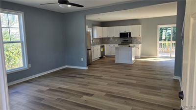 Kitchen featuring a healthy amount of sunlight, ceiling fan, appliances with stainless steel finishes, and white cabinets | Image 2