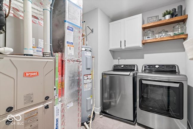 laundry area with cabinet space, separate washer and dryer, water heater, and heating unit | Image 33